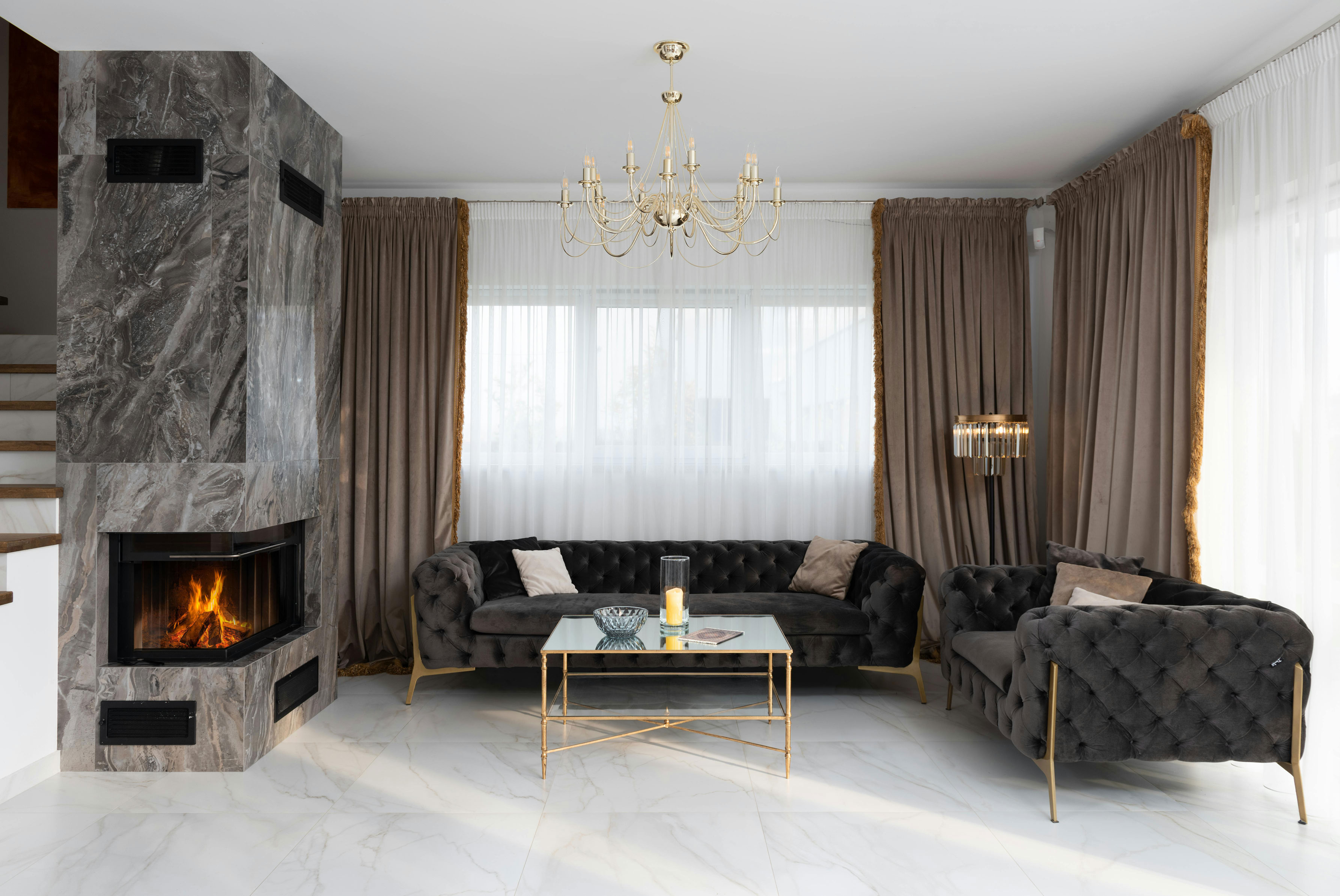 This image depicts a moody living room featuring a stunning marble fireplace, adding elegance and richness to the space.